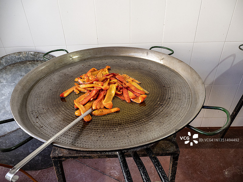 准备瓦伦西亚海鲜饭，将红辣椒放入橄榄油中煎。图片素材