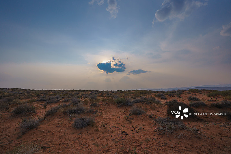 沙漠中的日落，多云的天空背景，为文本复制空间图片素材