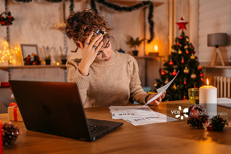 忧心忡忡的女人在圣诞节管理家庭财务图片素材