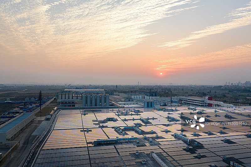 在浪漫的天空下，工厂屋顶上壮丽的太阳能电池板图片素材