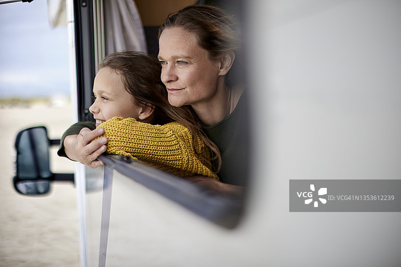 母亲和女儿看着窗外的露营车图片素材