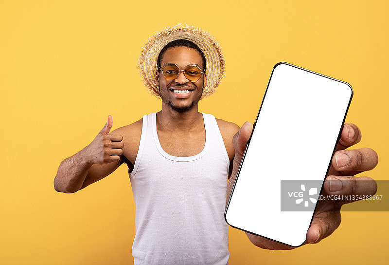 快乐的黑人游客展示手机与空白屏幕图片素材