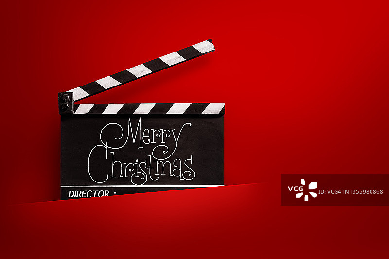 圣诞快乐，电影石板上的字迹。红色的背景。图片素材