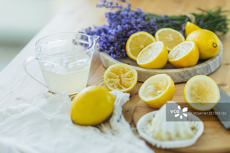 柠檬榨汁机和柠檬汁放在厨房桌子上。图片素材