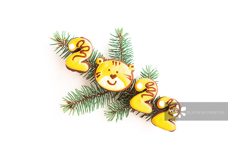 圣诞树的树枝与姜饼饼干在22号的形状与老虎印隔离在白色的背景。新年的象征。图片素材