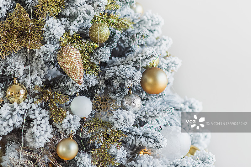 用金色和白色装饰的人造雪装饰的豪华圣诞树。图片素材