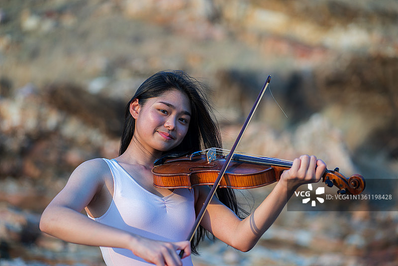 亚洲女性小提琴手演奏。图片素材