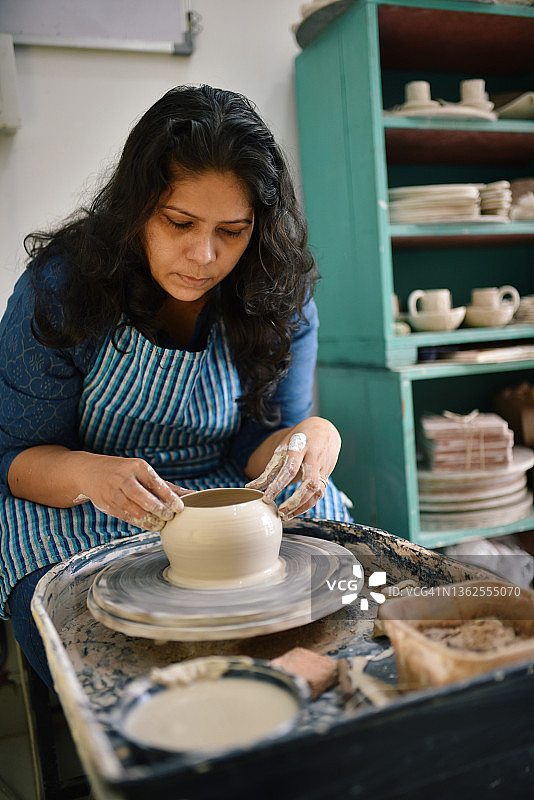 一个女陶艺师在她的陶轮上工作图片素材
