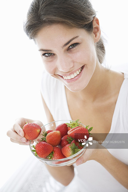微笑着吃草莓的女人图片素材