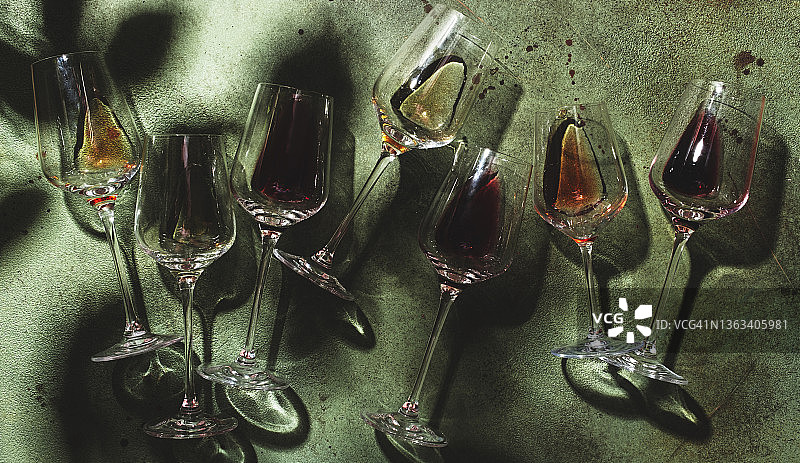 红色，玫瑰和白葡萄酒的玻璃锈绿色背景，俯视图。强光和阴影图片素材