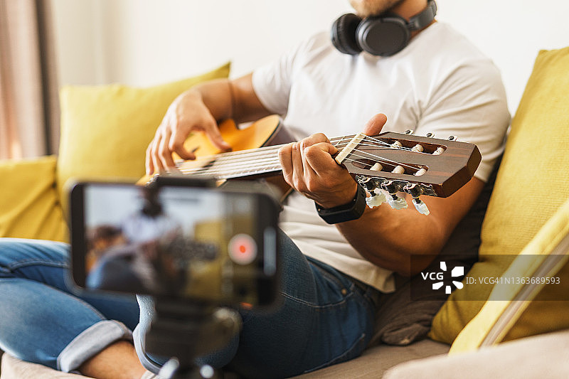 在沙发上弹奏原声吉他的音乐家博客图片素材