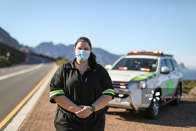 一位女性护理人员站在他的应急车辆前。图片素材