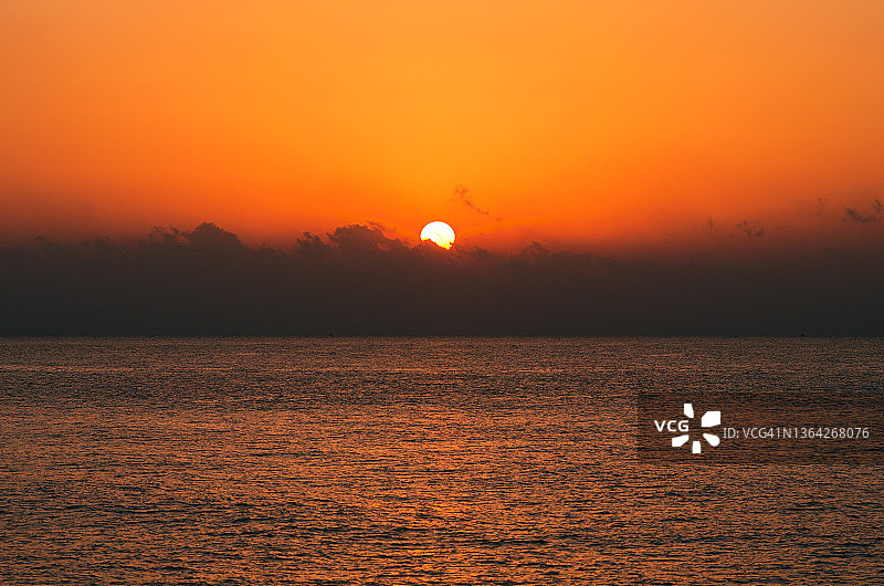 太阳从云的上方升起。早晨的海景。土耳其梅尔辛附近的地中海。旅游及旅游概念图片素材