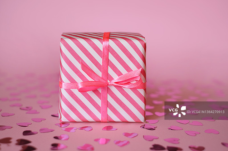 粉白色细条纹包装的礼物，用丝带和蝴蝶结系起来图片素材
