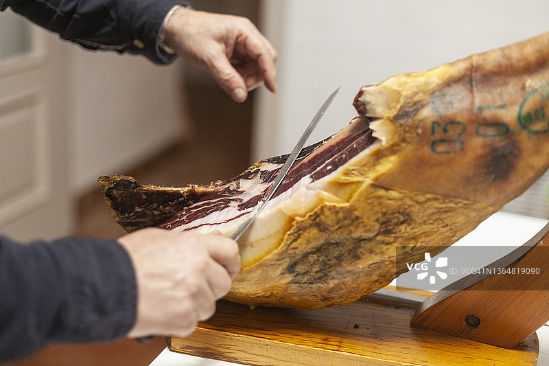 男性切割伊比利亚火腿的特写镜头。西班牙安达卢西亚的哈恩省图片素材