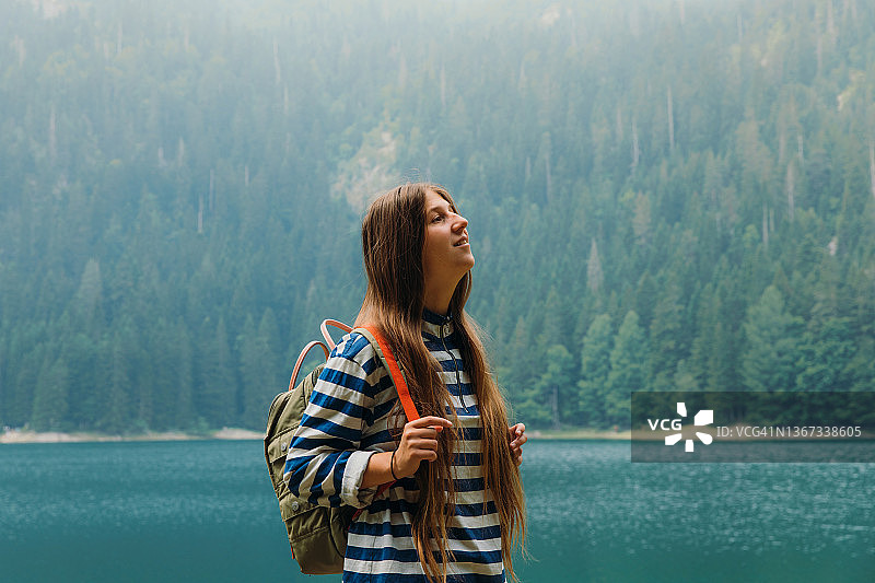 女游客在日出时探索风景优美的山湖图片素材