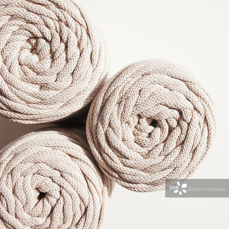 手工编织编织和棉线在白色背景。爱好针织棉纱卷筒。天然棉绳。女性的爱好。本空间图片素材