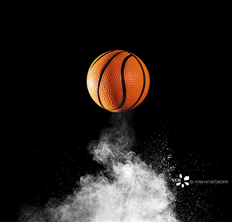 篮球在地面上的冲击和反弹，在黑色背景上的粉末图片素材