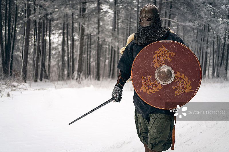 难以辨认的中世纪骑士，漫步在雪原森林图片素材