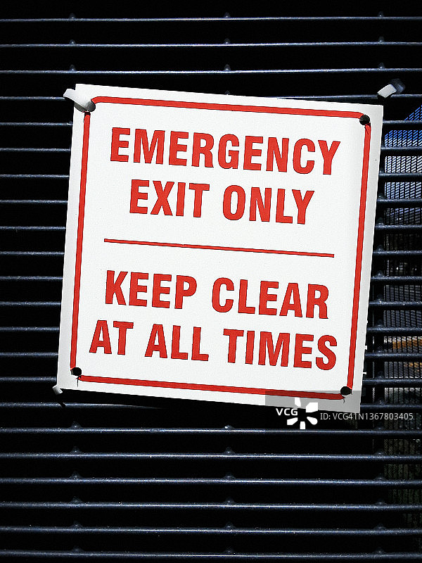 紧急出口的标志贴在板条钢门上，敦促人们远离它图片素材