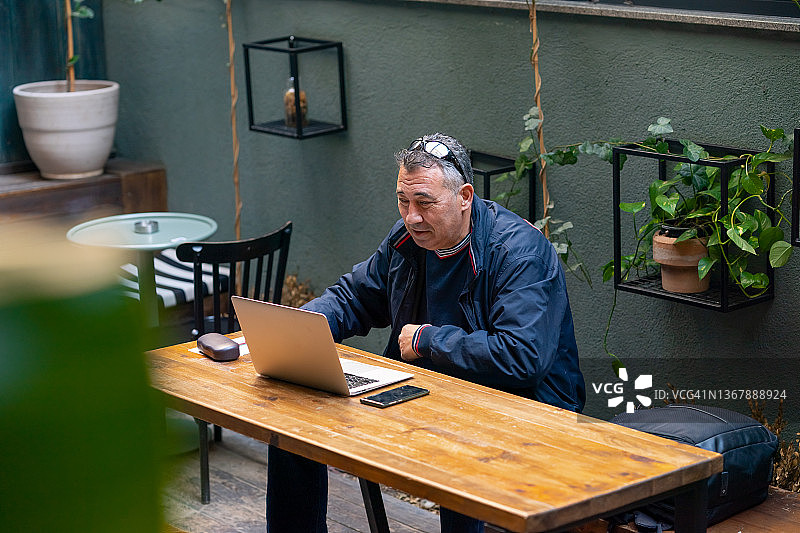 一个成年人在咖啡馆用笔记本电脑工作图片素材