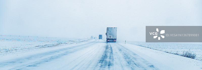 货运卡车在雪天暴风雪中行驶图片素材