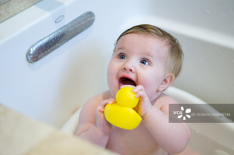 快乐宝宝和玩具鸭子洗澡图片素材