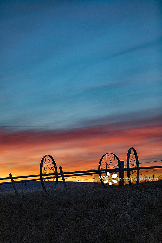 美国，爱达荷州，贝尔维尤，夕阳下农田里灌溉轮的剪影图片素材