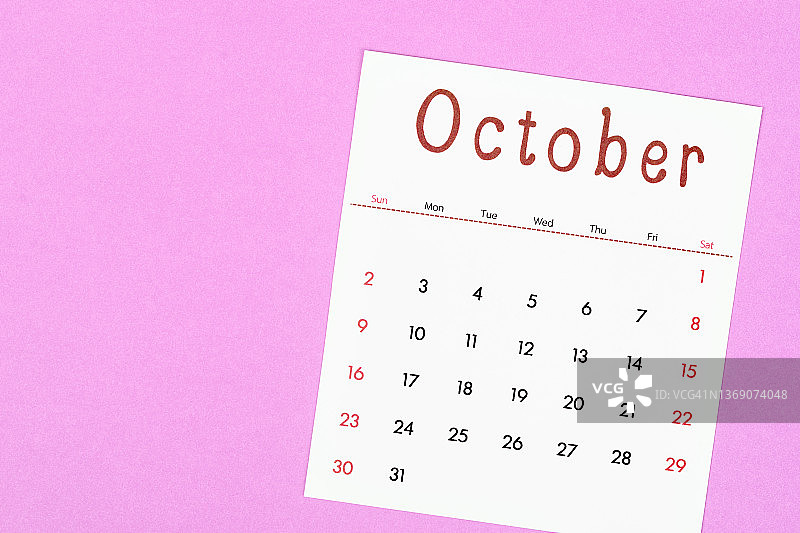 10月是组织者计划和提醒的月份，用洋红色的纸做背景。商业计划预约会议概念图片素材