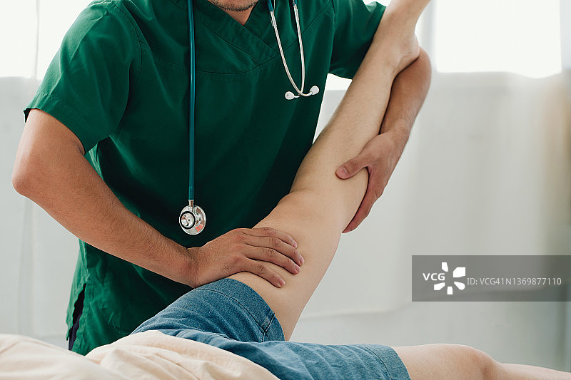 现代临床治疗大腿受伤疼痛的咨询治疗师。治疗久坐引起的大腿疼痛物理康复的概念。图片素材