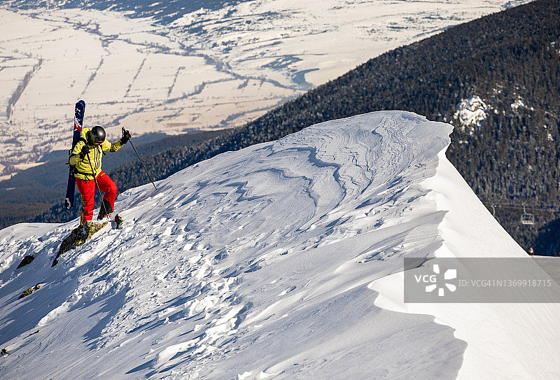 在滑雪胜地的山脊上搭便车的滑雪者图片素材