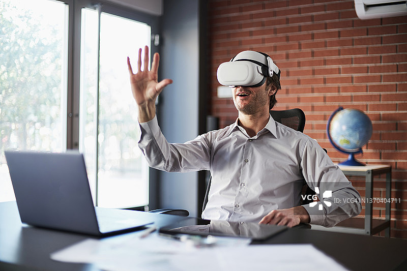 商务人士戴着VR头盔在家开商务会议图片素材