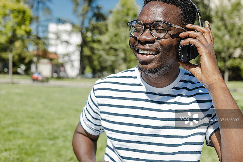 年轻的非洲裔美国人面带微笑，戴着耳机图片素材