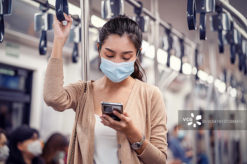 年轻女子戴着医用口罩，乘地铁出行图片素材