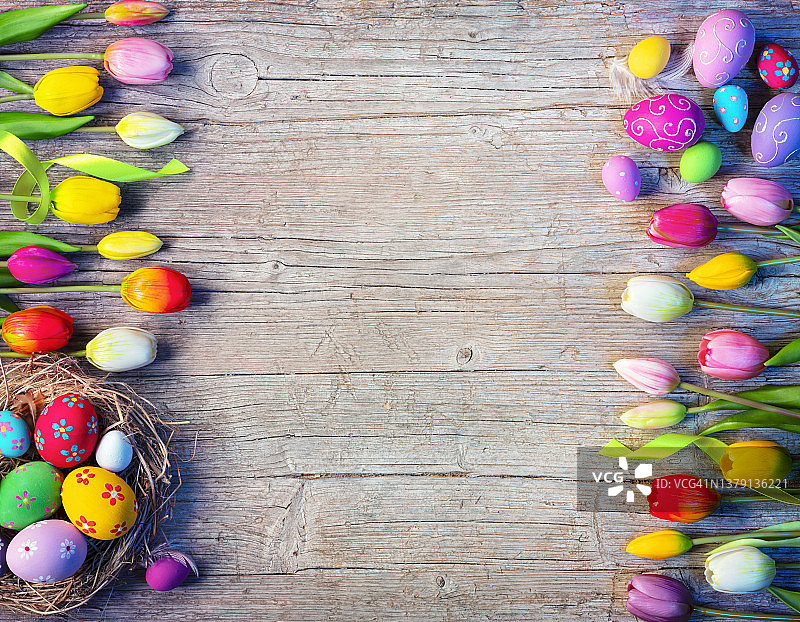 复活节板与鸡蛋装饰和郁金香在自然木制桌子上图片素材