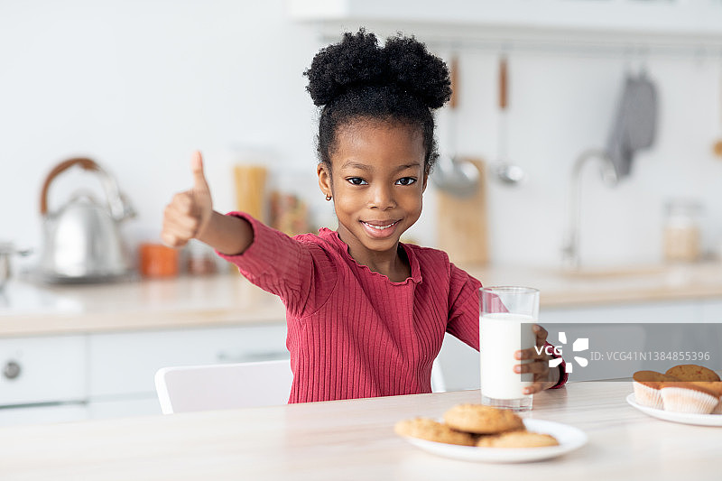 快乐的非洲裔美国小孩喝着牛奶，竖起大拇指图片素材