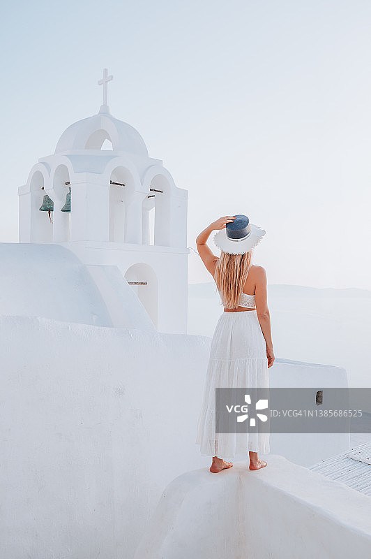 年轻女子喜欢在希腊圣托里尼岛旅行和观赏风景图片素材