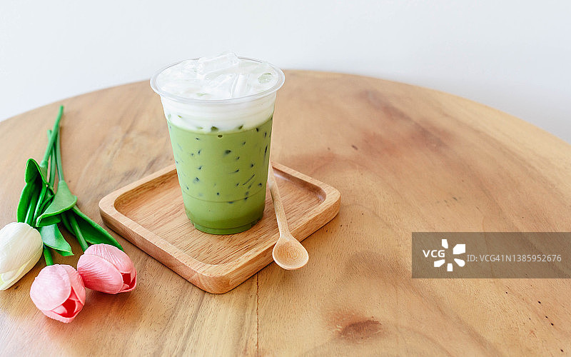 木制桌子上的塑料杯冰绿茶图片素材