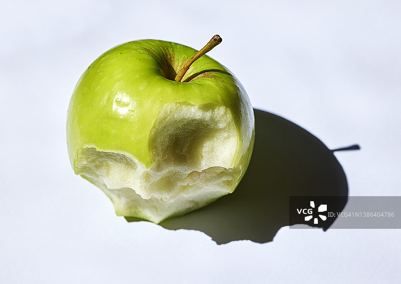 青苹果缺咬，部分被吃掉，茎，灰色背景，特写图片素材