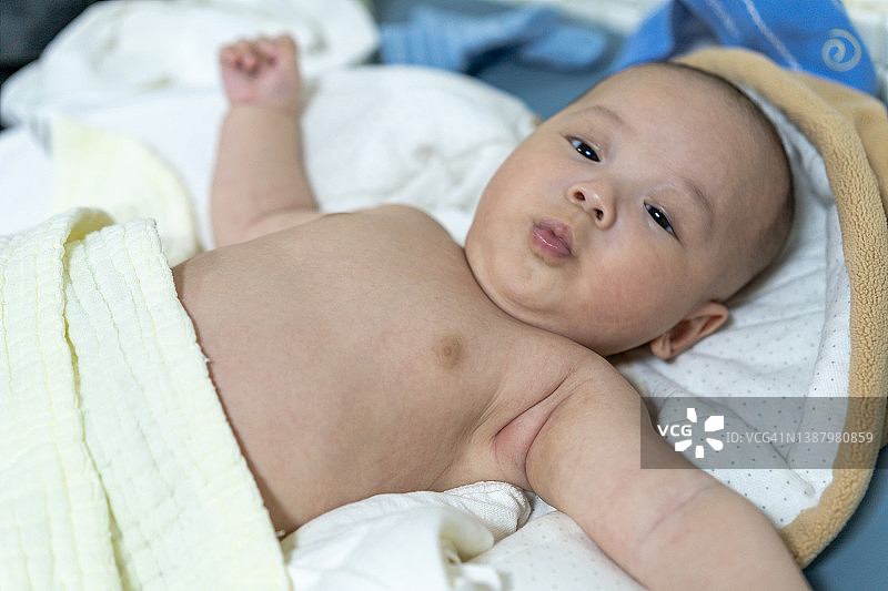 一个刚洗完澡的亚洲宝宝在噘嘴。图片素材