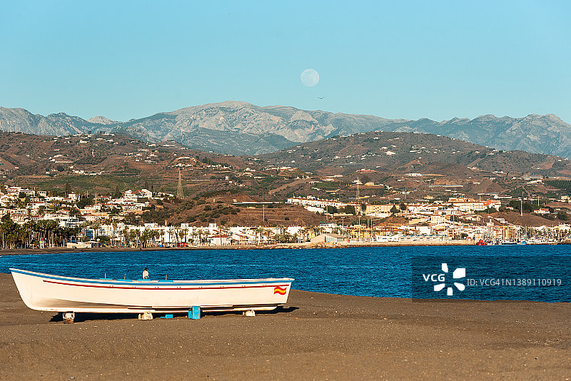 西班牙船和海滩。月亮和山脉在背景中。图片素材