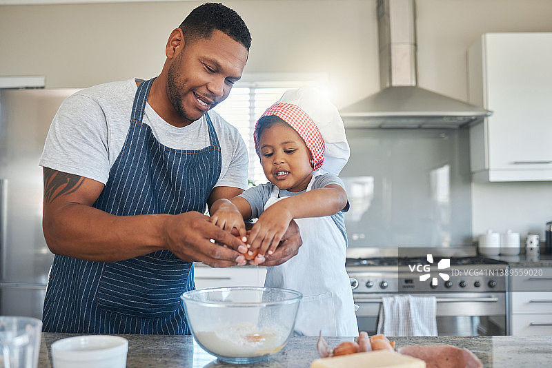 一个父亲和他的儿子在家里的厨房里烤面包图片素材