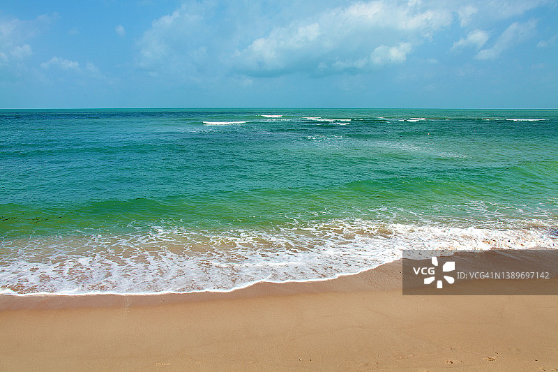阳光明媚的日子里，空旷的热带沙滩和碧蓝的海水图片素材