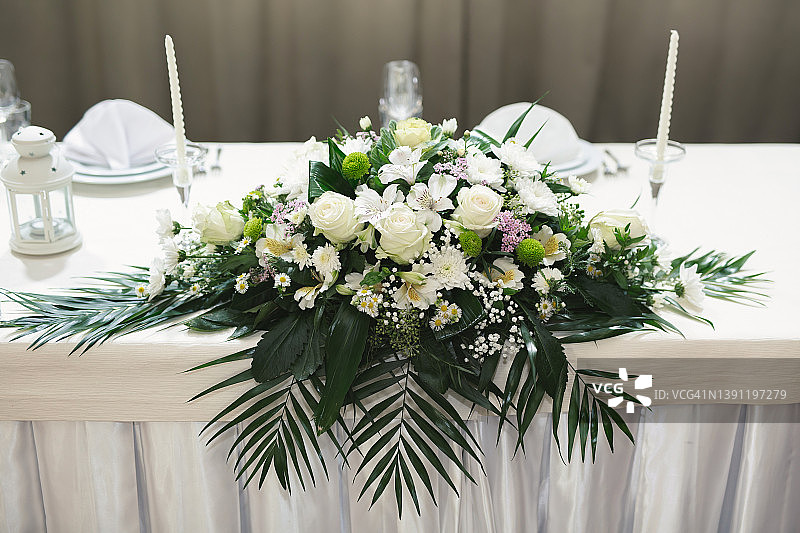 婚礼花卉装饰在白色的宴会在餐厅图片素材