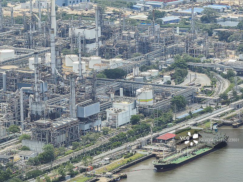 鸟瞰图，油轮停靠在河边的炼油厂港口卸货。关于能源进出口业务。图片素材