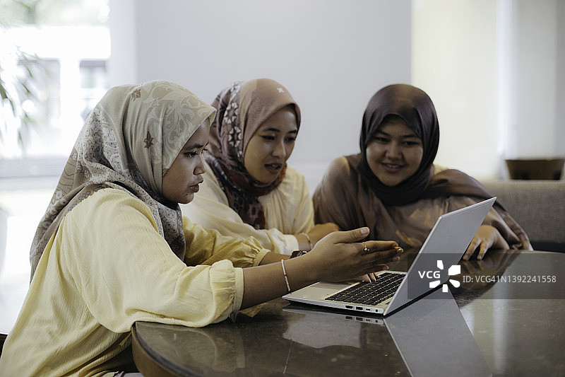 肖像穆斯林妇女工作和学习使用笔记本电脑图片素材