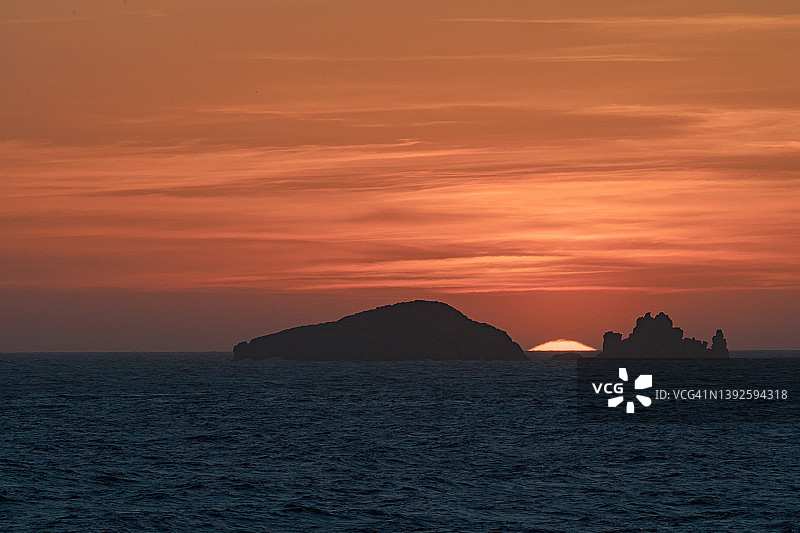 伊比沙岛一些小岛之间的巨大太阳的日落，风景摄影图片素材