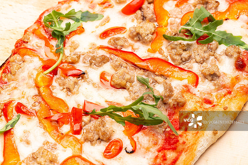 美味的披萨装在木盘子里。概念广告传单和海报的餐厅或披萨店，模板与美味的口味。图片素材