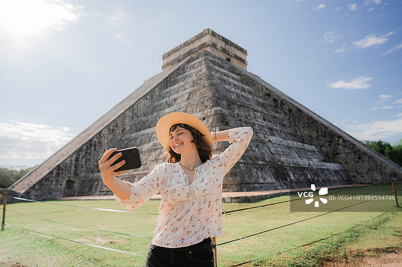 以墨西哥奇琴伊察金字塔为背景的女子自拍图片素材
