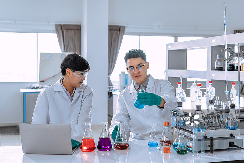 一群在实验室工作的亚洲男性科学家。医生和科学家在实验室工作的冠状病毒大流行，covid - 19的概念图片素材
